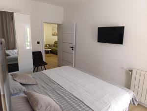 a bedroom with a bed and a flat screen tv at Apartman Ladini Lana in Starigrad-Paklenica