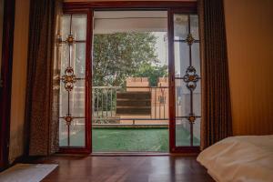 a bedroom with an open door to a balcony at The OG Stay - Luxury Apartment Ajmer in Ajmer