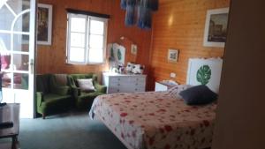 a bedroom with a bed and a couch and a chair at A casiña de Morais in Pontevedra