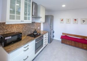a kitchen with white cabinets and a bench in it at Apartament Mickiewicza in Rumia +7 photos