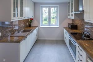 a kitchen with white cabinets and a window at Apartament Mickiewicza in Rumia