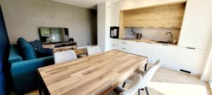 a kitchen and dining room with a wooden table and chairs at Apartament na wzgórzu in Lidzbark Warmiński +8 photos