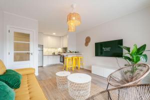 un soggiorno con divano, sedie e TV di Yellow Breeze Apartament a Viana do Castelo