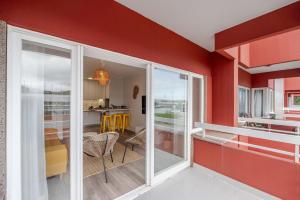 un soggiorno con pareti rosse e porte scorrevoli in vetro di Yellow Breeze Apartament a Viana do Castelo