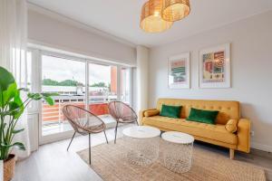 un soggiorno con un divano e due poltrone di Yellow Breeze Apartament a Viana do Castelo