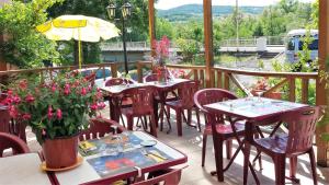 a patio with tables and chairs on a balcony at Hôtel restaurant de l'Île in Jumeaux