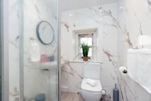 Un baño con inodoro, lavabo y espejo. en Nelson cottage- WiFi-parking-M65-Hospital- town -food- shops- contractor, en Nelson