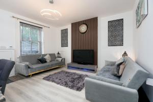 Una sala de estar con dos sofás y un televisor. en Nelson cottage- WiFi-parking-M65-Hospital- town -food- shops- contractor, en Nelson