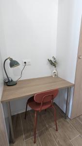 a wooden desk with a red chair and a lamp at Studio cosy neuf calme -Parking Terrasse privée Piscine 5mn Gare TGV Aix et ZA Aix la Duranne 15 mn Aéroport Marseille in Cabriès +16 photos
