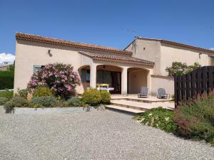 una casa con due sedie davanti di Gîte le Platane a Montagnac