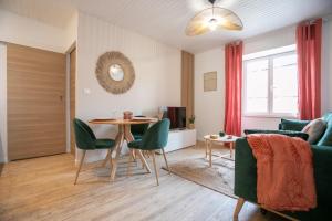 a living room with a table and green chairs at Bel appartement neuf en plein centre in Brantôme