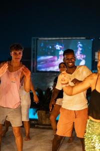 a group of young men dancing on a stage at EBS Hostel Phuket in Ban Karon