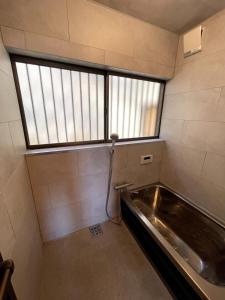 an empty room with a large window and a metal tub at Relaxing 石川町 サウナ付き一棟貸しの宿 in Yokohama