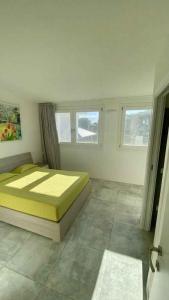 ein Schlafzimmer mit einem Bett und zwei Fenstern in der Unterkunft Holiday home in Isola di Albarella 43996 in Palazzo Vianello