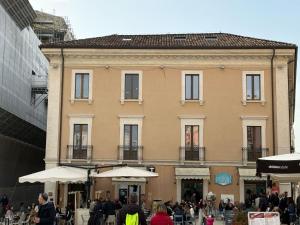a large building with people walking in front of it at San Massimo Apartment - Piazza Duomo L'Aquila in LʼAquila