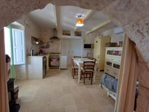 a kitchen and dining room with a table and chairs at trullo fino in Cisternino
