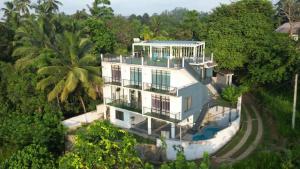 an aerial view of a white house with trees at Aura Residence-Kandy in Katugastota
