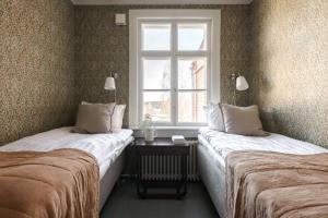 two beds in a room with a window at Vinhan Kirjakauppa in Ruovesi