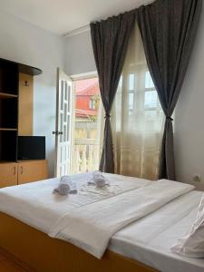 a bedroom with a large white bed with a window at Casa Elenisse in 2 Mai