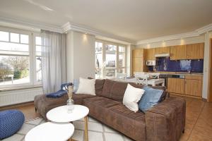 レーメにあるFerienwohnung mit traumhaftem Meerblick - Haus am Meer FeWo 08のリビングルーム(ブラウンソファ付)、キッチンが備わります。 +26枚の写真
