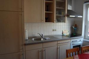 a kitchen with a sink and a stove at Gästehaus am Fischerweg in Lauterbach +49 photos