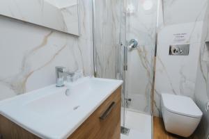 ein Badezimmer mit einem weißen Waschbecken und einer Dusche in der Unterkunft Desire Home in Bari
