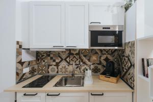 eine Küche mit weißen Schränken und einer Spüle in der Unterkunft Desire Home in Bari + 24 Fotos