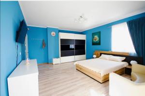 a blue bedroom with a bed and a tv at Къща за гости,, Зафир,, in Sofia