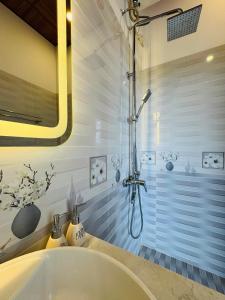 eine Badewanne mit Dusche im Bad in der Unterkunft Hue Panorama Villa in Cư Chinh