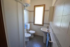 a bathroom with a toilet and a sink and a mirror at Raffaella in Bibione