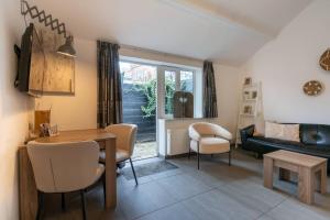 a living room with a table and chairs and a couch at Hello Zeeland - Vakantiehuis Wijngaardstraat 12A in Domburg