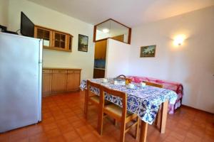 a kitchen with a table and a refrigerator at Raffaella in Bibione +15 photos