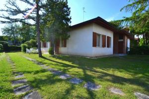 a small house in a yard with a tree at Raffaella in Bibione
