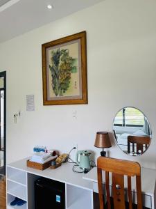 einen Schreibtisch mit einem Spiegel und einen Tisch mit einer Lampe in der Unterkunft Hue Panorama Villa in Cư Chinh