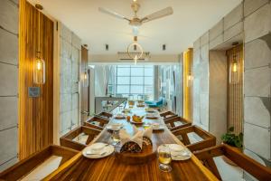 HarnaiSaffronStays Nautica - 5BR hilltop villa with rooftop pool, sea views & modern interiors surrounded by greenery的大型用餐室设有长木桌