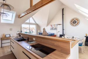an attic kitchen with a counter top and a sink at L'Abri Côtier d'Argäe - Terrasse vue mer in Erquy
