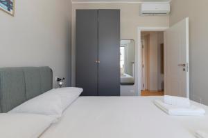 a bedroom with a white bed and a mirror at I Host Apartment - Coni Zugna 58 in Milan