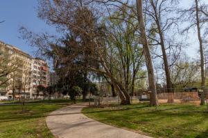 a path in a park with trees and a building at I Host Apartment - Coni Zugna 58 in Milan