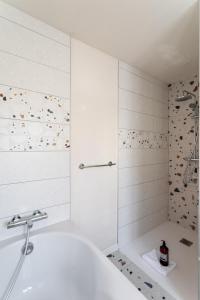 a bathroom with a tub and a shower at L'Abri Côtier d'Argäe - Terrasse vue mer in Erquy