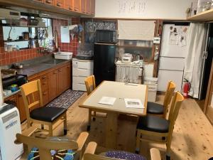 a kitchen with a table and chairs in it at ゲストハウスやごろう in Iizuka