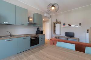 a kitchen with blue cabinets and a wooden table at I Host Apartment - Coni Zugna 58 in Milan