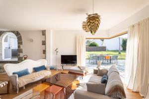 Una sala de estar con dos sofás y un televisor. en Les Bulles d'Or - A 400m de la plage, en Fréhel