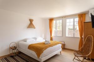 Un dormitorio con una cama y dos sillas. en Les Bulles d'Or - A 400m de la plage, en Fréhel