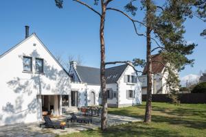 una casa blanca con árboles delante en Les Bulles d'Or - A 400m de la plage, en Fréhel
