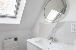 un baño con lavabo y espejo en Les Bulles d'Or - A 400m de la plage, en Fréhel 22 fotos más