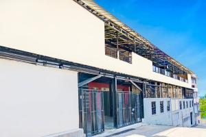 un edificio blanco con puertas y puertas metálicas en Dancenter Pasteur Near Near Paris Van Java Mall, en Bandung