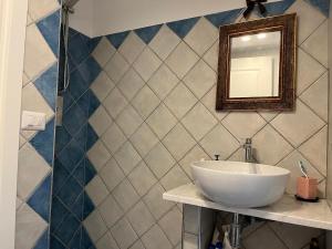 une salle de bain avec un lavabo et un miroir au mur dans l'établissement L'Hermitage- Monte Argentario, à Monte Argentario 61 autres photos