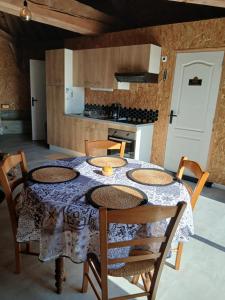 a kitchen with a table with chairs and a table cloth at Le Manège in Thiétreville