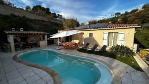 a swimming pool in front of a house at Maison Love Lane in Cagnes-sur-Mer