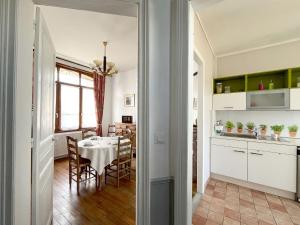 a kitchen and dining room with a table and chairs at Maison meulière du 34e Sacre, à proximité du Domaine Pommery in Reims